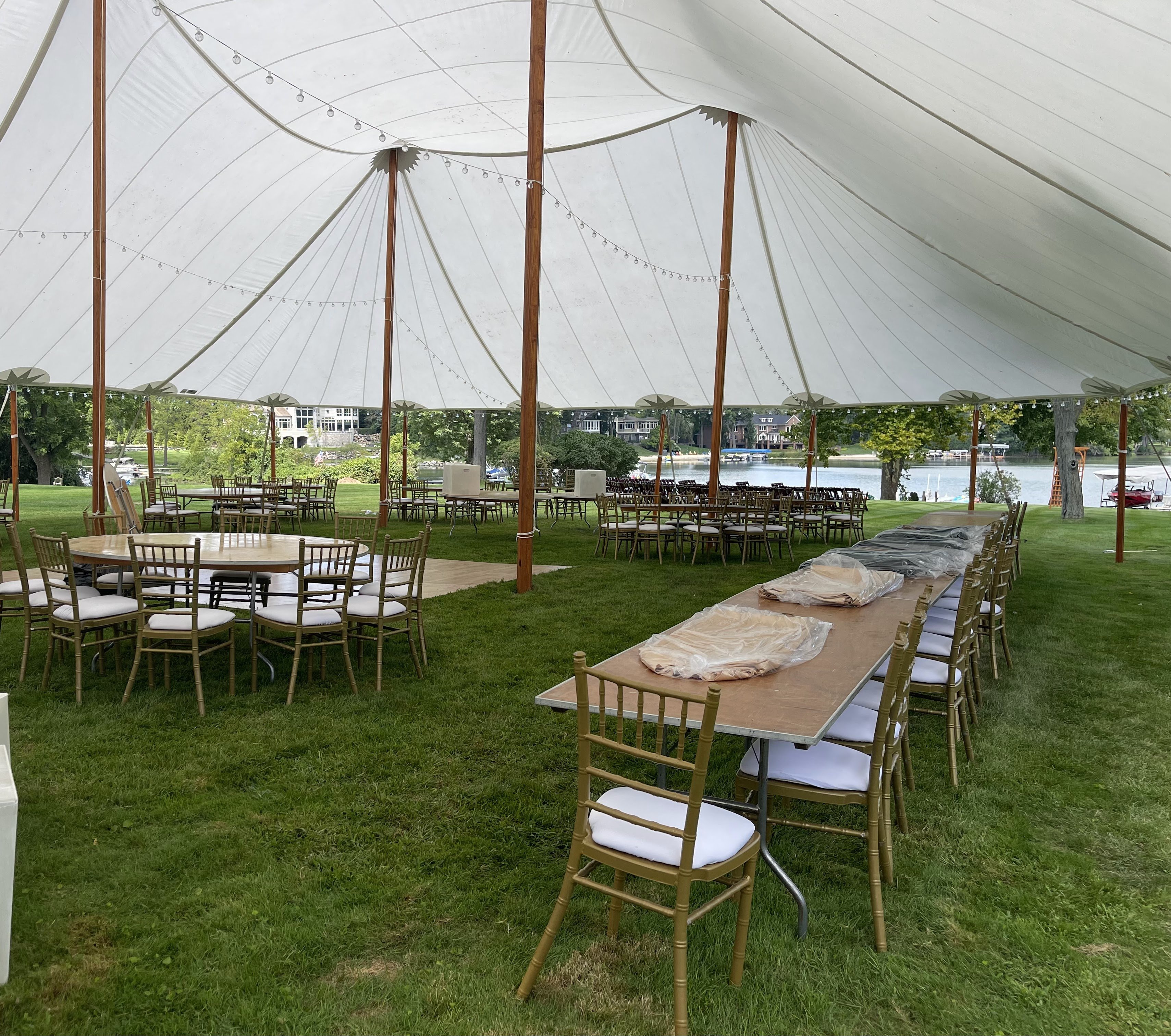 Sailcloth tent with gold chiavari chairs and lakefront views for a waterfront wedding